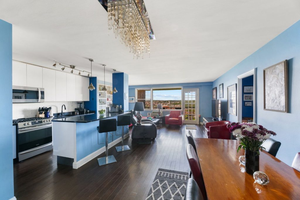 A two-bedroom, one-bath, roughly 900-square-foot apartment with an open floor plan, an updated kitchen, an updated windowed bathroom, through-the-wall air-conditioning and a balcony, on the top floor of a 22-story doorman building with a live-in super, electric car charging stations, a garage, a gym, swimming pools, tennis and basketball courts, a dog park, a playground, bike storage and basement storage cages.